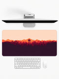 Amber Horizon deskmat featuring mountain silhouettes, forest scenery, and sunset-inspired artwork