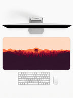 Amber Horizon deskmat featuring mountain silhouettes, forest scenery, and sunset-inspired artwork