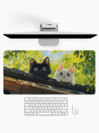 Curious Kittens deskmat featuring black and white cats peeking over a wall