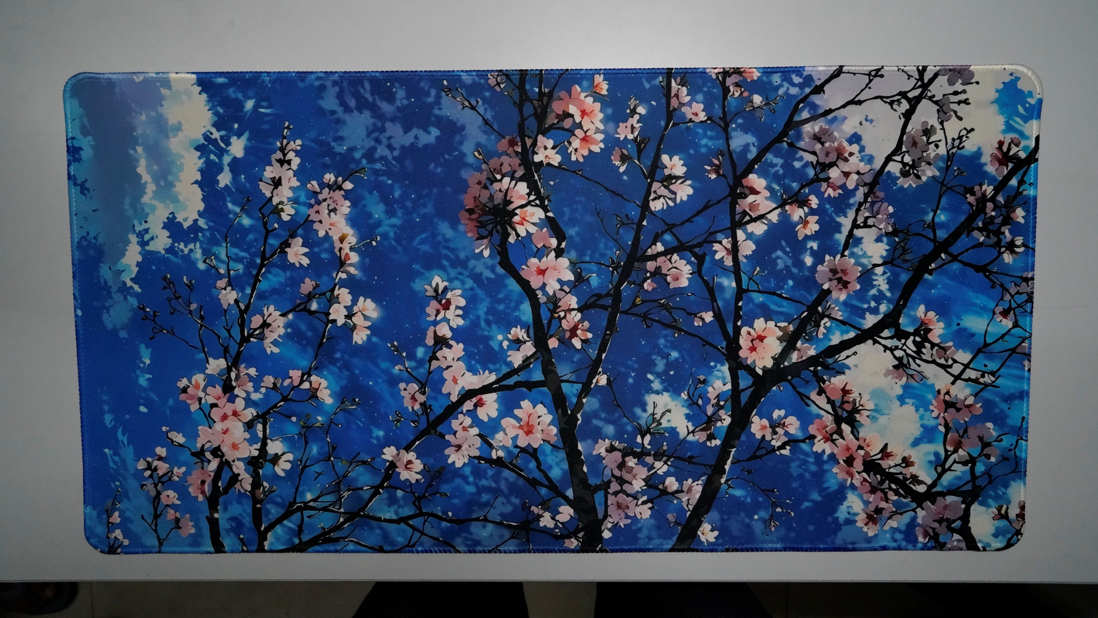 Sakura Sky deskmat featuring cherry blossom branches against a bright blue sky